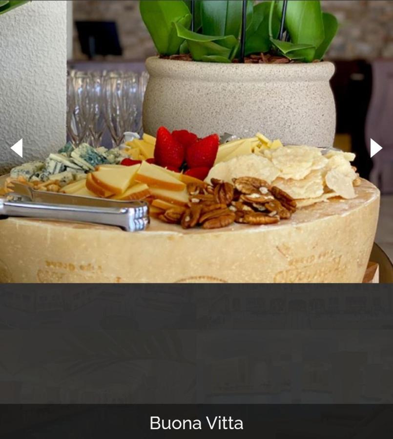 Buona Vitta Gramado Resort & Spa By Gramado Parks Exterior foto The photo displays a beautiful cheese platter. It features a large round cheese wheel as the base, surrounded by various types of cheeses including soft and hard varieties. There are also some crackers or crisps, along with nuts, particularly pecans.