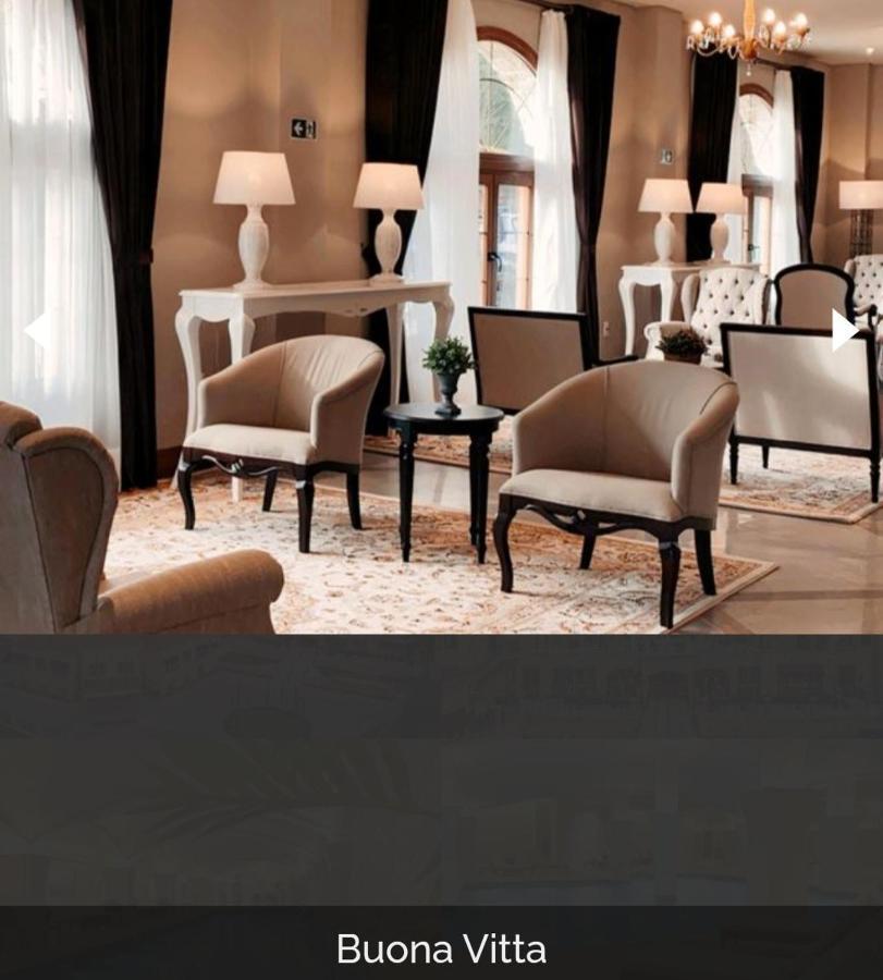 Buona Vitta Gramado Resort & Spa By Gramado Parks Exterior foto The photo shows a stylish and inviting interior space, likely a lounge or waiting area. There are beige upholstered armchairs arranged around a small black table. A decorative plant is placed on the table. Behind the chairs are light-colored walls wi