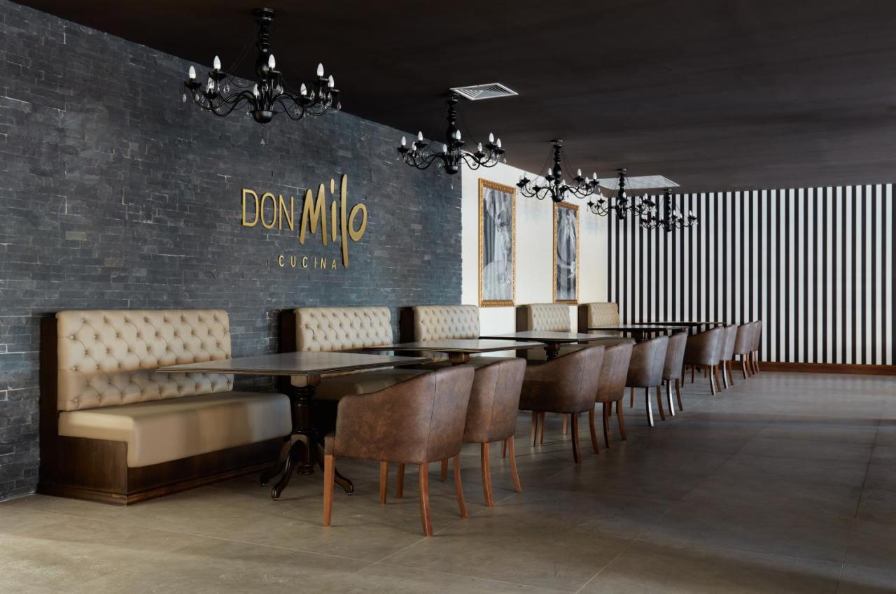 Buona Vitta Gramado Resort & Spa By Gramado Parks Exterior foto The photo showcases an interior of a restaurant named "Don Milo." The design features a modern and sophisticated look with a mix of textures and colors. 

On one side, there are upholstered booths in a neutral tone, creating a comfortable dining area