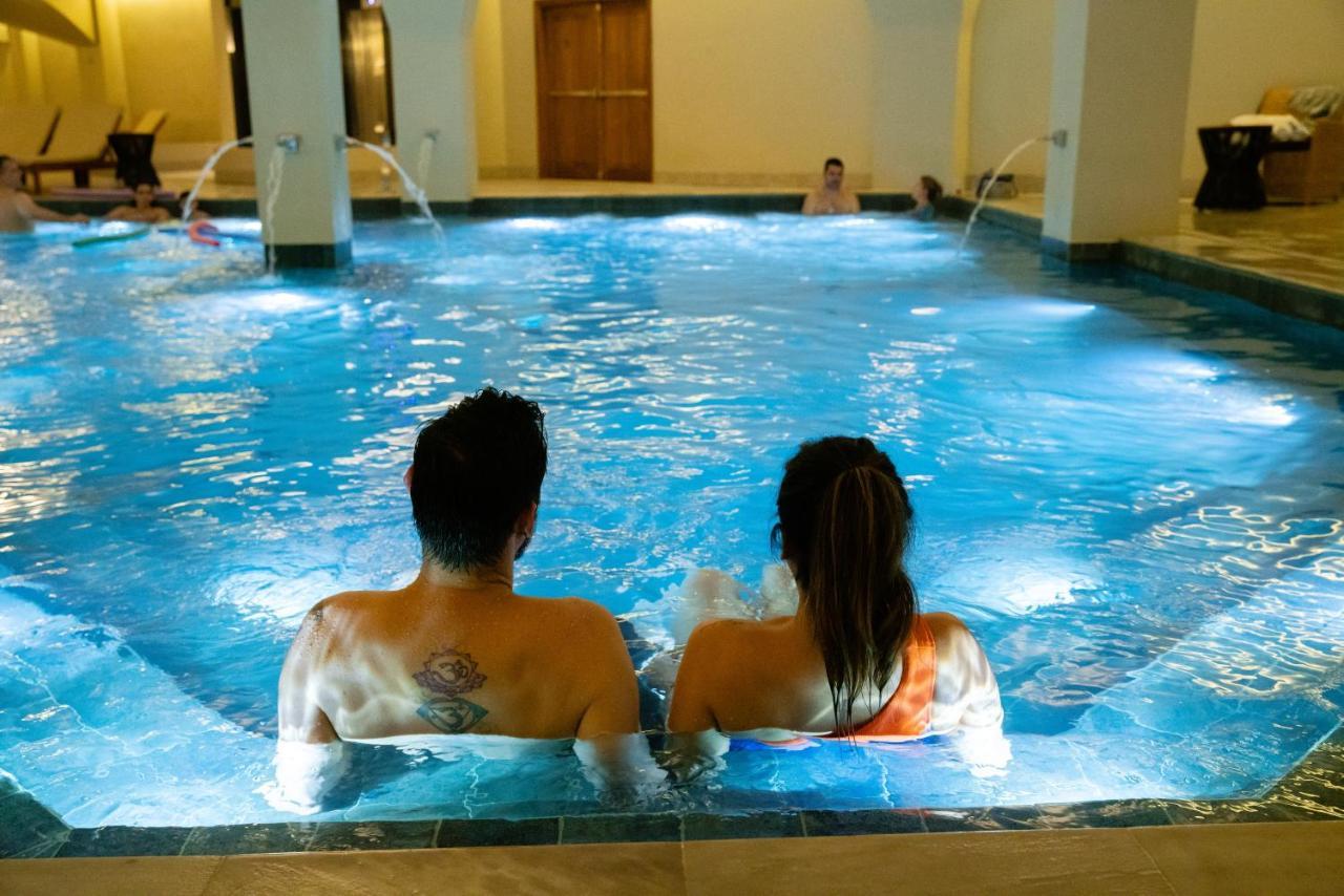 Buona Vitta Gramado Resort & Spa By Gramado Parks Exterior foto The photo shows a couple sitting in a swimming pool with gentle lighting. They are facing away from the camera, appearing relaxed and enjoying their time together. The water is illuminated with a soft blue light, creating a serene atmosphere. In the 